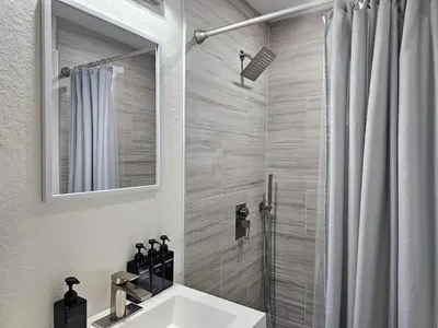 a bathroom with a sink and a shower with a mirror at The Ruby - Hot Tub - King beds - Close to LMC in Fort Lauderdale