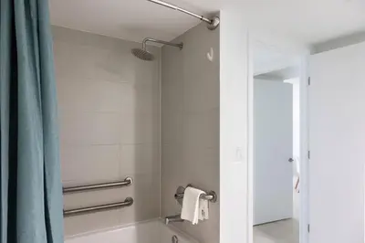 a bathroom with a tub and a shower with a mirror at 1 BR Full Kitchen- Pool Gym Beach 29th floor in Hallandale Beach
