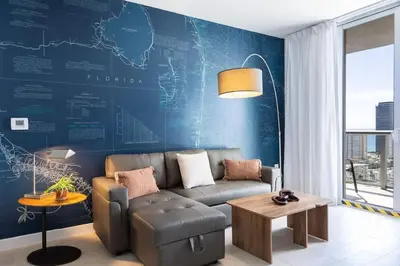 a living room with a couch and a blue wall at 1 BR Full Kitchen- Pool Gym Beach 29th floor in Hallandale Beach