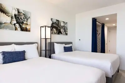 two beds sitting next to each other in a room at Family Beachwalk Studio- 29th floor in Hallandale Beach