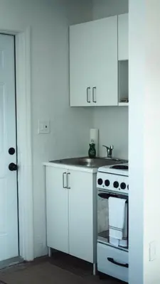 a kitchen with white cabinets and a stove at Cozy Miami Home Next to Wynwood & Design District in Miami