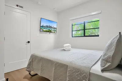 a white bedroom with a bed and a window at Prestige Retreat by Renzzi in Miami