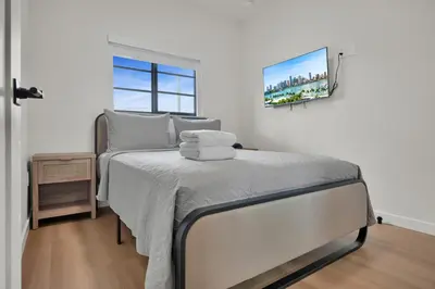 a bedroom with a bed with a tv on the wall at Prestige Retreat by Renzzi in Miami