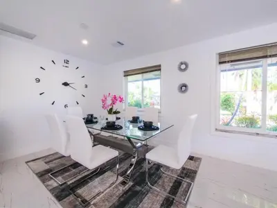 a dining room with a glass table and white chairs at Luxury,3Bed 2Bath ,Pool,Grill,Parking in Hollywod in Hollywood