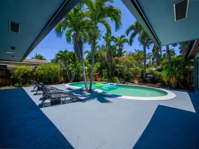 a swimming pool with two chairs and palm trees at Luxury,3Bed 2Bath ,Pool,Grill,Parking in Hollywod in Hollywood
