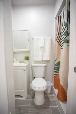 a white bathroom with a toilet and a sink at Cozy Modern Studio Near Sunny Isles & Bal Harbour in North Miami