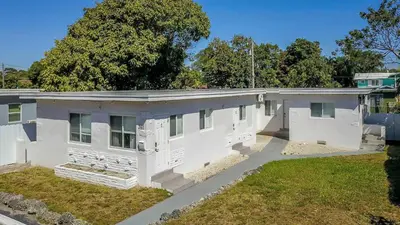 an older white house with a yard at N. Miami Studio | Stylish Stay Minutes from Ocean in North Miami