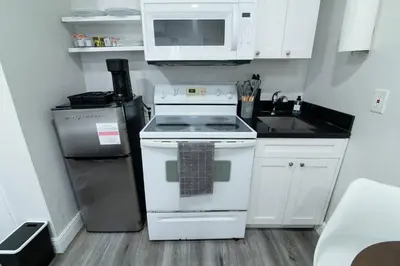 a small kitchen with a stove and a microwave at N. Miami Studio | Stylish Stay Minutes from Ocean in North Miami