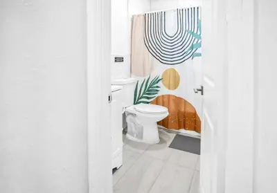 a bathroom with a toilet and a shower curtain at N. Miami Studio | Stylish Stay Minutes from Ocean in North Miami