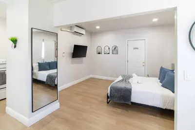 a bedroom with two beds and a mirror at Modern Studio Apt • Prime North Miami Location in North Miami