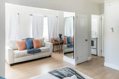 a living room with a couch and a mirror at Modern Studio Apt • Prime North Miami Location in North Miami