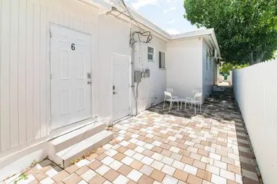 a house with a white door and a patio at Spacious North Miami Studio | 2 Queen Beds in North Miami
