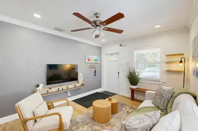 a living room with a couch and a flat screen tv at Palm & Pool Retreat in Fort Lauderdale