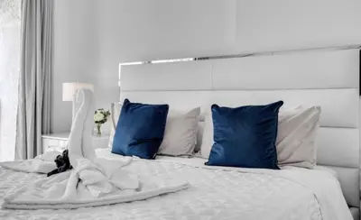 a bedroom with a white bed with blue pillows at Skyline with Water views 2 bedroom in Miami