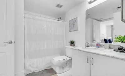 a white bathroom with a toilet and a shower at Skyline with Water views 2 bedroom in Miami