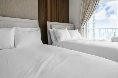 two white beds in a hotel room with a window at Stunning 3B2B with Ocean and City Views - Free Parking in Miami