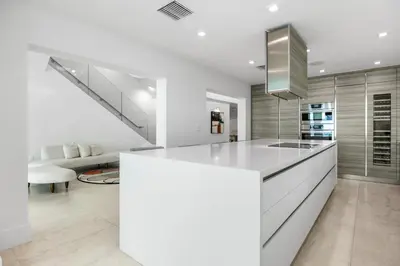 a kitchen with white countertops and a staircase at Miami Modern Heated Pool and Dock in Sunny Isles Beach