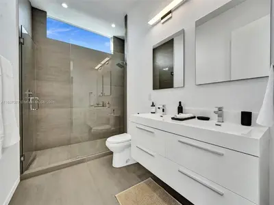 a white bathroom with a toilet and a shower at Modern waterfront property in Fort Lauderdale