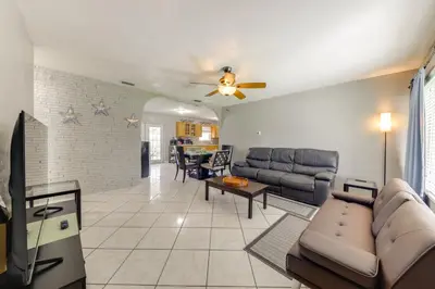 a living room with a couch and a table at Fenced-In Yard Home 3 Mi to Hard Rock Stadium! in Miramar