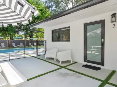 a patio with two white chairs and a pool at Miami Escape Parking Pool Near Wynwood in Miami