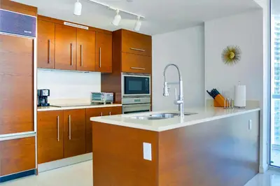 a kitchen with wooden cabinets and a sink at Luxury Living in Brickell - Stunning City Views in Miami