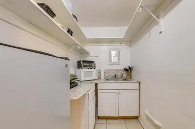 a small kitchen with white cabinets and a microwave at 8 Mi to Beach! Miramar Guest Suite with Pool Access in Miramar