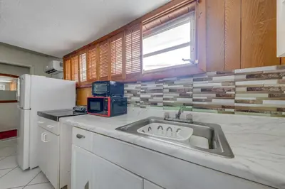 a kitchen with a sink and a white refrigerator at 5 Mi to Hollywood Blvd! Miramar Apt with Shared Pool in Miramar