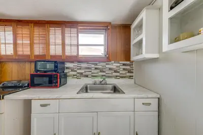 a kitchen with a sink and a microwave at 5 Mi to Hollywood Blvd! Miramar Apt with Shared Pool in Miramar