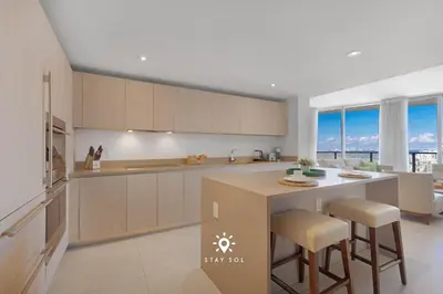 a kitchen with a island with stools in it at Beautiful 1BR Apartment with Ocean View Balcony in Hollywood
