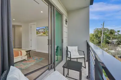 a bedroom with a balcony with a bed and a chair at New 4BR Upscale Family Haven in Fort Lauderdale