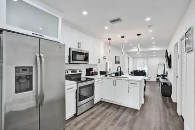 a kitchen with white cabinets and stainless steel appliances at Miami Heart Retreat, Stylish & Central With Games in Miami