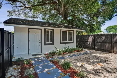 a small house with a fence and a tree at Heart of Miami Oasis, Modern, Steps from It All in Miami