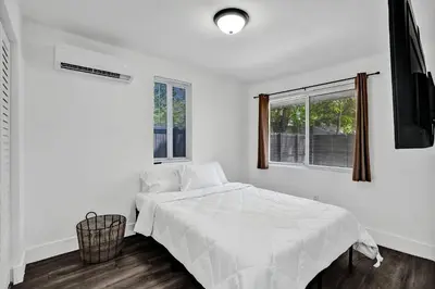 a white bedroom with a bed and two windows at Heart of Miami Oasis, Modern, Steps from It All in Miami
