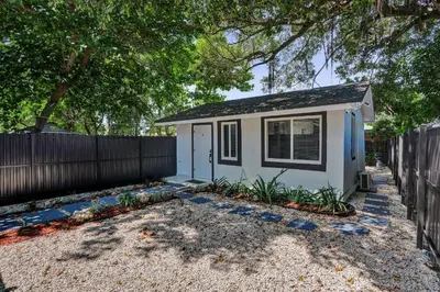 a small house with a fence in a yard at Heart of Miami Oasis, Modern, Steps from It All in Miami