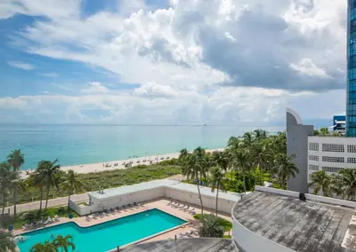 a view of the beach from the balcony of a resort at Casablanca Residences Miami Beach in Miami Beach