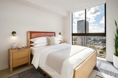 a bedroom with a bed and a large window at The Crosby Miami World Center in Miami