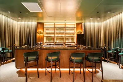 a bar in a restaurant with green chairs at Downtown Luxury Stay with Complimentary Parking in Miami