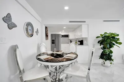 a dining room with a table and white chairs at Oceanfront Escape with Resort Amenities Gym Pools and Sauna 1408 in Miami Beach