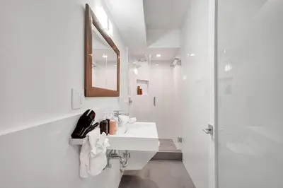 a white bathroom with a sink and a shower at Oceanfront Luxury 3BR 3BA Condo with Resort Pools Gym and Sauna 902 in Miami Beach