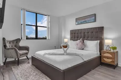 a bedroom with a bed and a chair and a window at Urban Escape 2 Bed Unit In Miami near Whole Foods in North Miami