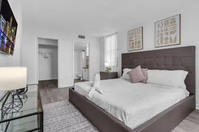 a bedroom with a large bed with white sheets at Urban Escape 2 Bed Unit In Miami near Whole Foods in North Miami