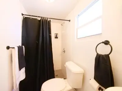 a bathroom with a black shower curtain and a toilet at Miami Wynwoods nook the graffiti stylish studio in Miami