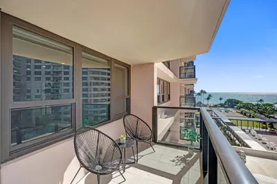 a balcony with two chairs and a view of the ocean at Modern 4BR with Ocean Views Pools and Direct Beach Access in Miami Beach