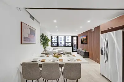 a kitchen and dining room with a table and a refrigerator at Modern 4BR with Ocean Views Pools and Direct Beach Access in Miami Beach