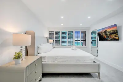 a white bedroom with a white bed and a window at Steps to the Beach 3BR 2BA Condo Resort Perks and Ocean Glimpse 1406 in Miami Beach