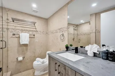 a bathroom with a sink and a toilet and a shower at Steps to the Beach 3BR 2BA Condo Resort Perks and Ocean Glimpse 1406 in Miami Beach