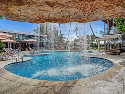 a pool with a waterfall in a resort at Steps to the Beach 3BR 2BA Condo Resort Perks and Ocean Glimpse 1406 in Miami Beach