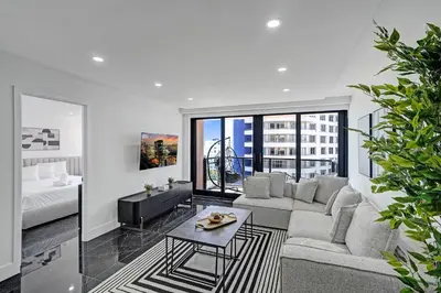 a living room with a couch and a bed and a table at Miami Beach Paradise 4BR Stylish condo with Resort Perks 1007 in Miami Beach