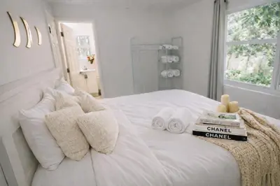 a bedroom with a white bed with towels on it at Prime Location Home W BBQ & Free Parking in Miami