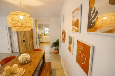 a dining room with a wooden table and a light fixture at Prime Location Home W BBQ & Free Parking in Miami